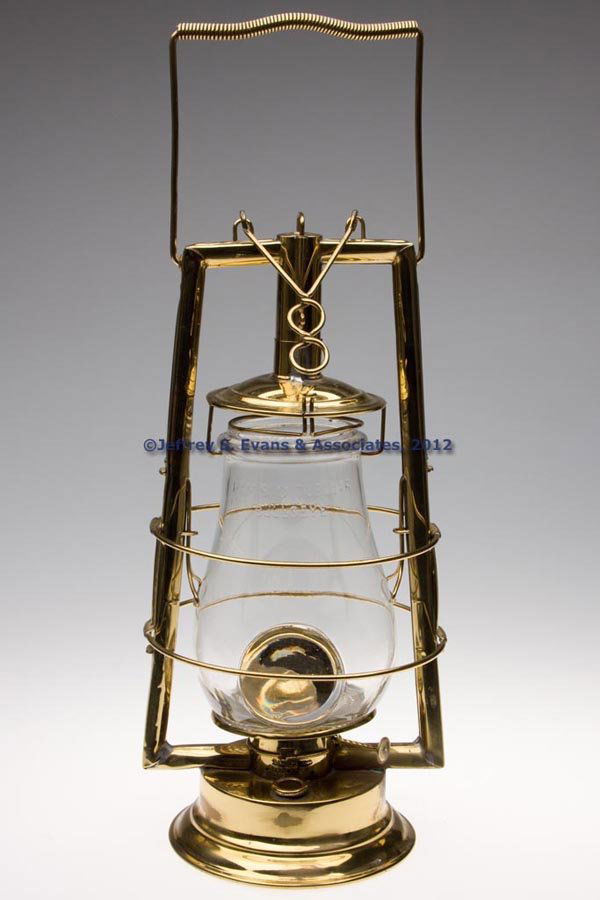 C. T. HAM BRASS HOT BLAST TUBULAR LANTERN WITH BUL: C. T. HAM BRASS HOT BLAST TUBULAR LANTERN WITH BULL'S-EYE LENS, polished, bail handle, lift wire and side spring globe feature, fitted with a colorless globe embossed "HAMS O TUBULAR BULLSEYE" and rev