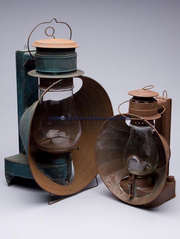 SHEET IRON COLD BLAST SEARCH LANTERNS, LOT OF TWO: SHEET IRON COLD BLAST SEARCH LANTERNS, LOT OF TWO, each with bail handle, cap with ring and hook for wall mounting, comprising a C. T. Ham Manufacturing Co.'s No. 40 "Mammoth", cover with worn stencil