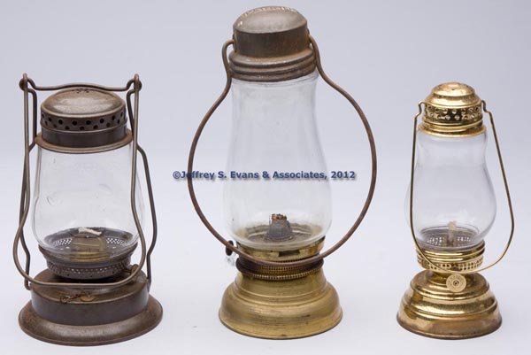 BRASS AND SHEET IRON KEROSENE LANTERNS, LOT OF THR: BRASS AND SHEET IRON KEROSENE LANTERNS, LOT OF THREE, each with bail handle, comprising a polished brass skater's lantern, thumbwheel marked "W. B. G. CORP. WATERBURY. CT."; a brass and sheet iron exa