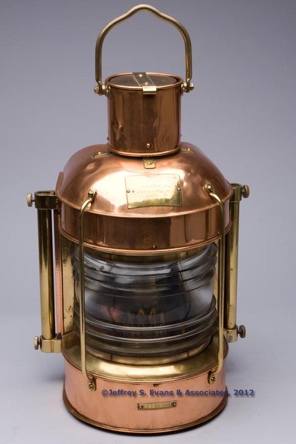 NIPPON SENTO CO. BRASS AND COPPER MASTHEAD MARINE: NIPPON SENTO CO. BRASS AND COPPER MASTHEAD MARINE LANTERN, polished, bail handle and hinged cover, flat back with four mounting lugs connected with cylinders, reverse fitted with a hinged door and inc