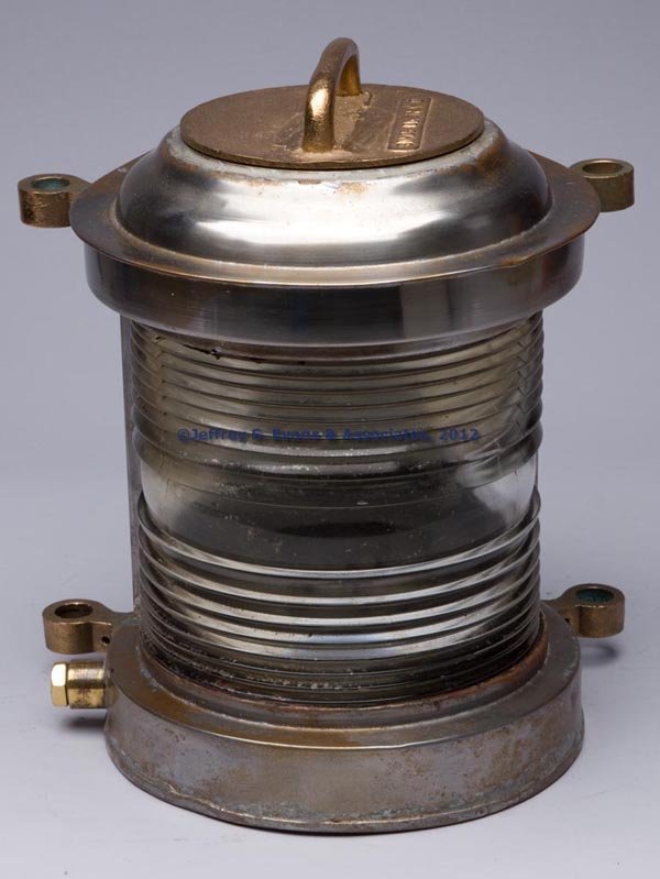 SIMES CO. CAST BRONZE AND SHEET IRON ELECTRIC MARI: SIMES CO. CAST BRONZE AND SHEET IRON ELECTRIC MARINE LIGHT, removable cover with handle embossed "SIMES CO. N.Y.C.", flat back and four mounting lugs, colorless fresnal lens. 20th century. 13 3/4" HOA