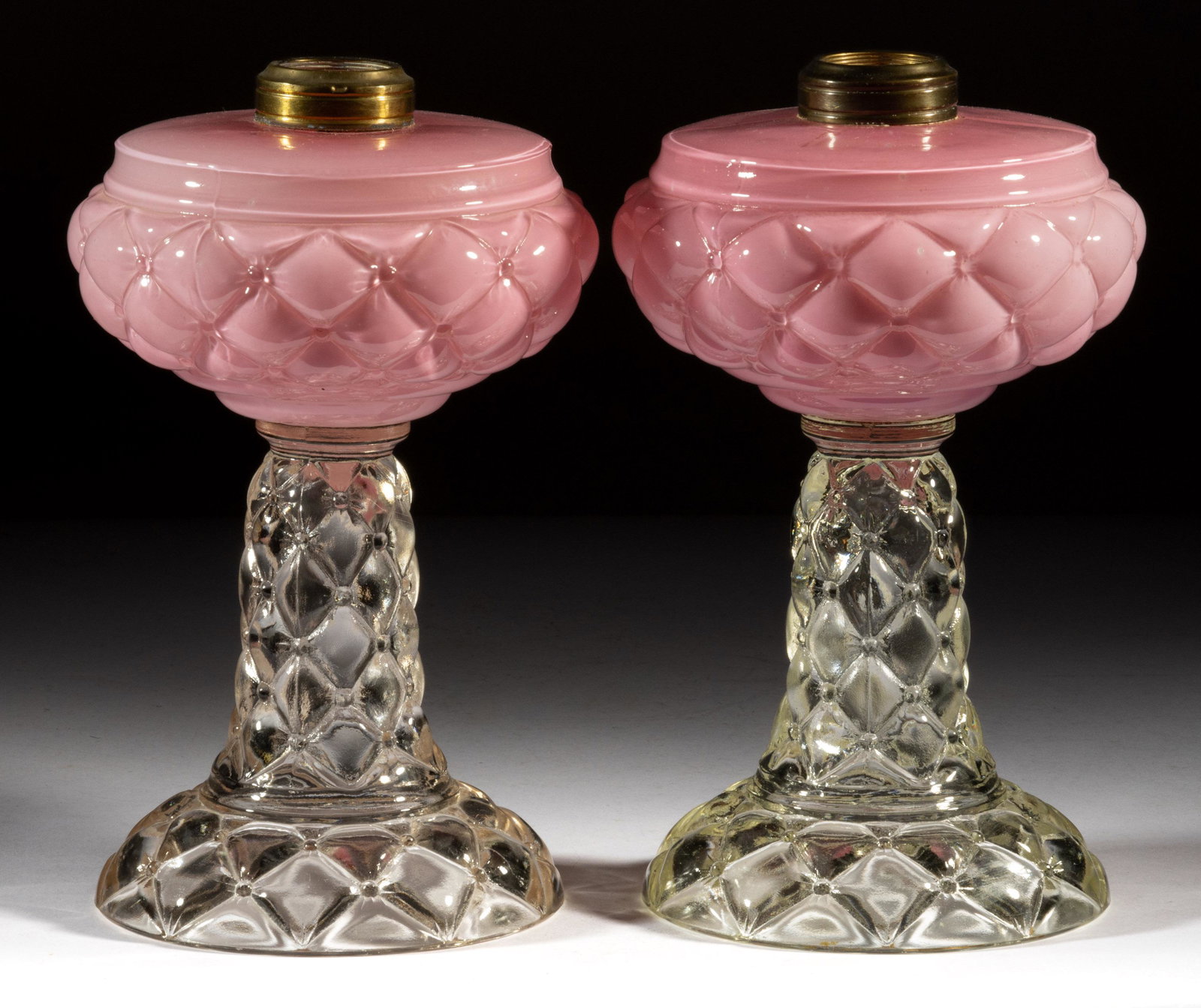 QUILT / FLORETTE PAIR OF KEROSENE STAND LAMPS: QUILT / FLORETTE PAIR OF KEROSENE STAND LAMPS, cased pink fonts, colorless bases, each having a No. 2 Taplin-Brown collars. Consolidated Lamp & Glass Co. Circa 1894. 9 3/8" and 9 1/2" H 