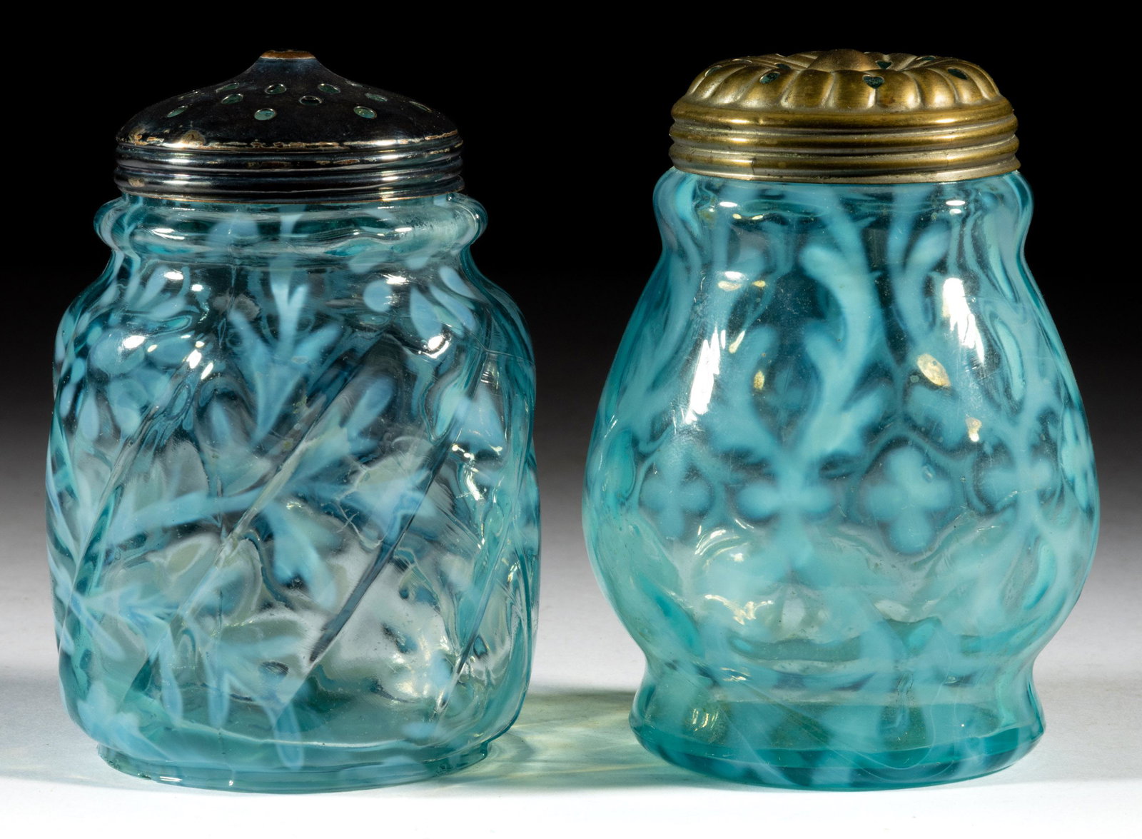 ASSORTED OPALESCENT GLASS SUGAR SHAKERS, LOT OF TWO: ASSORTED OPALESCENT GLASS SUGAR SHAKERS, LOT OF TWO, blue opalescent, comprising a Spanish Lace and a Daisy and Fern Swirl, each having a period lid. Various makers. Late 19th/early 20th century. 4 1/