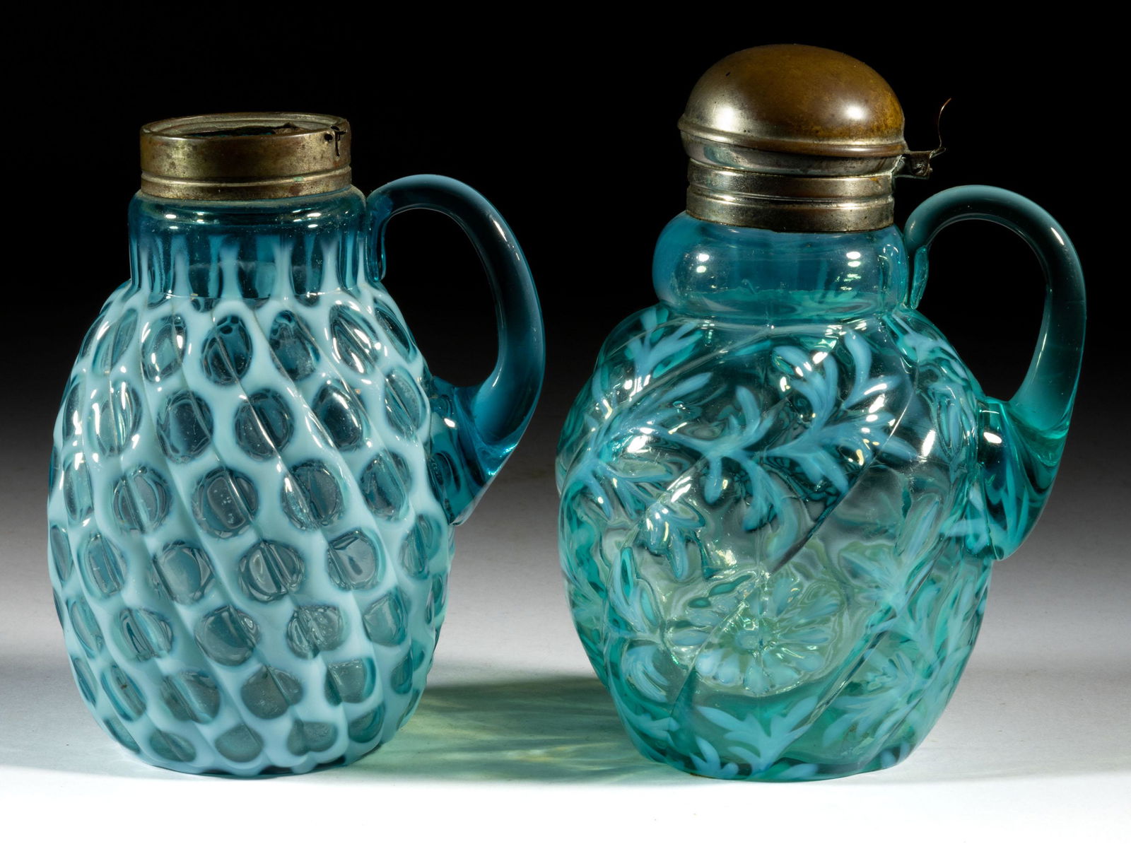 ASSORTED OPALESCENT GLASS SYRUP PITCHERS, LOT OF TWO: ASSORTED OPALESCENT GLASS SYRUP PITCHERS, LOT OF TWO, blue opalescent, comprising a Big Windows with a period collar, but lacking a lid, and a Daisy and Fern with a Northwood Swirl mold, period l