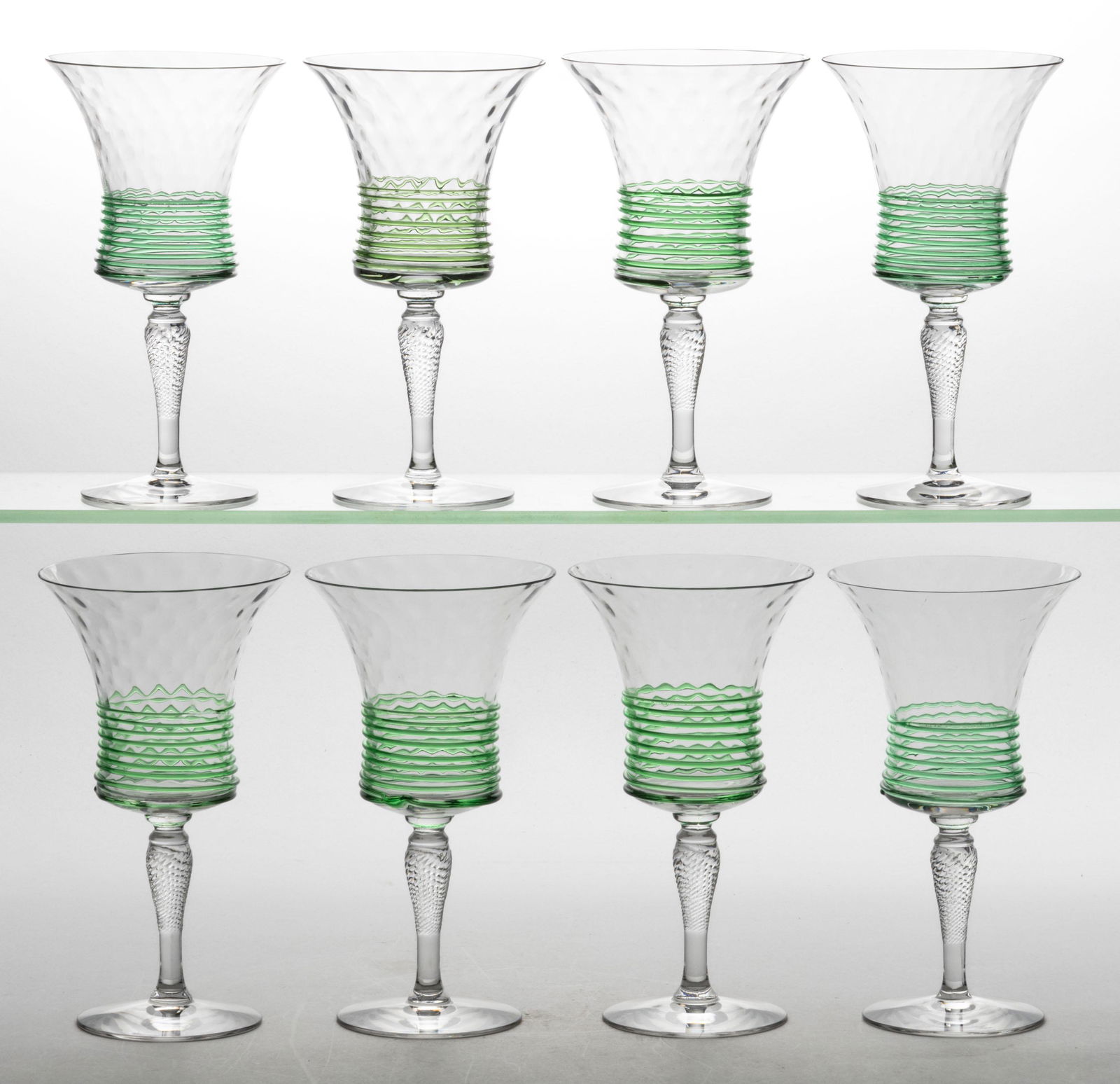 FRY THREAD-DECORATED DIAMOND-OPTIC GOBLETS, SET OF EIGHT: FRY THREAD-DECORATED DIAMOND-OPTIC GOBLETS, SET OF EIGHT, colorless with applied emerald green threading to lower bowl, raised on twisted stems. H. C. Fry Glass Co. Circa 1925. 7 1/2" H.Literatur