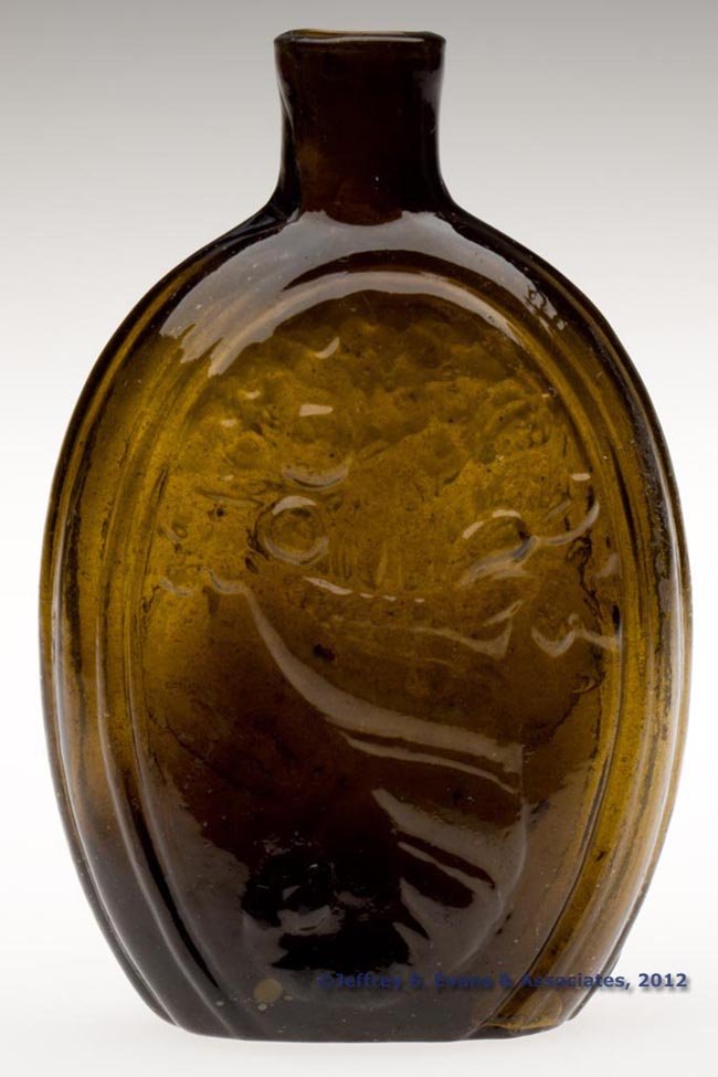 GIII-8 CORNUCOPIA - URN PICTORIAL FLASK: GIII-8 CORNUCOPIA - URN PICTORIAL FLASK, olive amber, half-pint, faint pearl to left of cornucopia, sheared mouth, light rough pontil mark. New England, probably Keene or Coventry Glass Works. 1825-18
