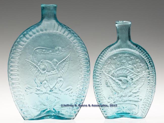 TWO EAGLE PICTORIAL FLASKS: TWO EAGLE PICTORIAL FLASKS, aquamarine, comprising a pint GII-24 and a quart GII-26, each with sheared mouth and rough pontil mark. Midwestern United States, possibly Kentucky Glass Works, Louisville,