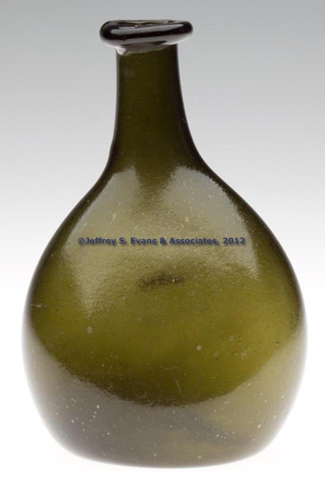 FREE-BLOWN DIMINUTIVE CHESTNUT-FORM FLASK: FREE-BLOWN DIMINUTIVE CHESTNUT-FORM FLASK, olive green, finely pebbled/chilled surface, flattened ovoid body with medium neck and crude rolled-over rounded mouth, kick-up base with rough pontil mark. 