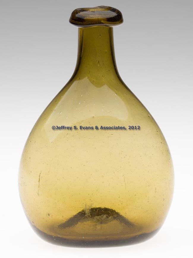 FREE-BLOWN DIMINUTIVE CHESTNUT-FORM FLASK: FREE-BLOWN DIMINUTIVE CHESTNUT-FORM FLASK, yellow olive amber, flattened ovoid body with medium neck and crude rolled-over rounded mouth, kick-up base with rough pontil mark. Probably New England. 178