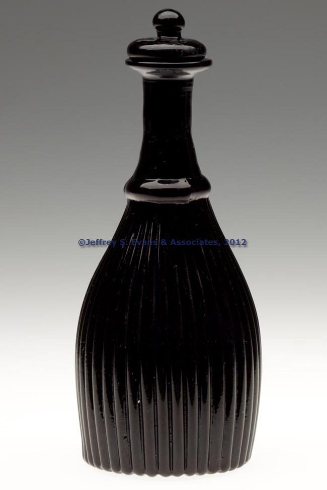 BLOWN-MOLDED GI-7 TYPE II CRUET OR TOILET BOTTLE: BLOWN-MOLDED GI-7 TYPE II CRUET OR TOILET BOTTLE, unlisted nearly opaque black amethyst, plain flanged mouth above an unpatterned neck, Rayed Type I base with rough pontil mark, original opaque black 