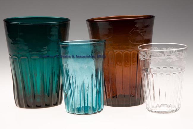 ASSORTED PATTERN-MOLDED TUMBLERS, LOT OF FOUR: ASSORTED PATTERN-MOLDED TUMBLERS, LOT OF FOUR, colored and colorless, three molded with panels and one with ribs, each with rough pontil mark. 19th and/or 20th century. 4" to 5 5/8" H. Provenance: Col