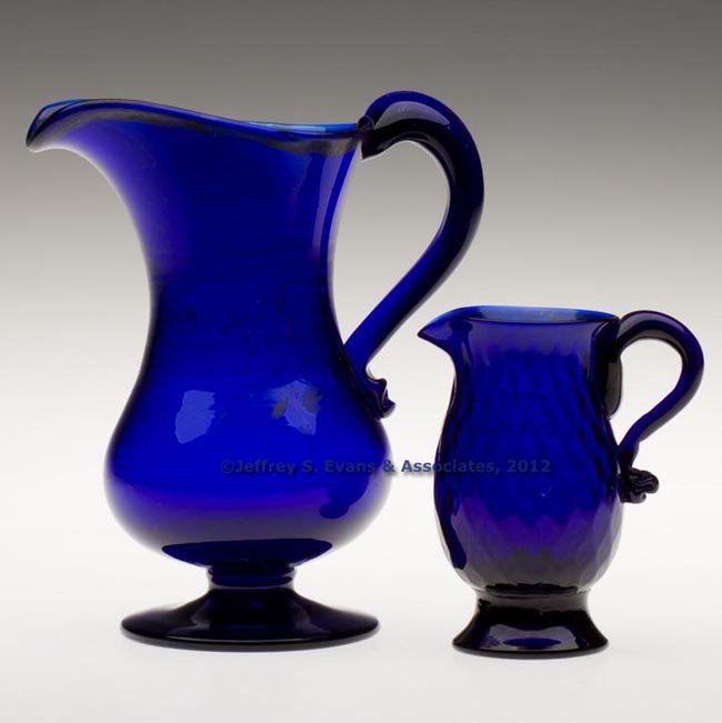 TWO BLOWN CREAMERS: TWO BLOWN CREAMERS, cobalt blue, comprising a pattern-molded expanded-diamond example with applied funnel foot and rough pontil mark, and a free-blown example with applied pedestal foot, polished pont