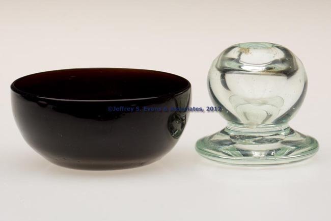 ASSORTED FREE-BLOWN ARTICLES, LOT OF TWO: ASSORTED FREE-BLOWN ARTICLES, LOT OF TWO, comprising a deep muddy amber bowl with kick-up base and rough pontil mark, and a pale green inkwell raised on a thick foot with rough pontil mark. Bowl possi