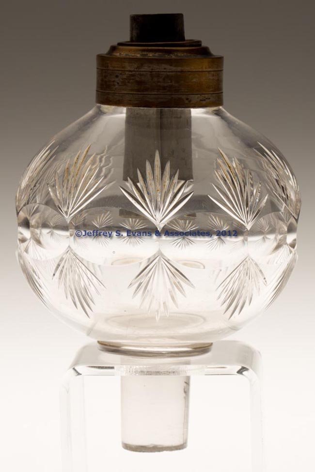 CUT COMPRESSED ROUNDELS AND FANS PEG LAMP: CUT COMPRESSED ROUNDELS AND FANS PEG LAMP, colorless, globular form with medial pattern, applied solid peg with ground bottom. Later collar and double-tube burner. Probably Pittsburgh region. 1830-185