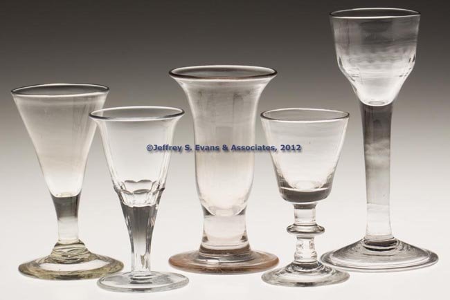 ASSORTED BLOWN DRINKING GLASSES, LOT OF FOUR: ASSORTED BLOWN DRINKING GLASSES, LOT OF FOUR, colorless lead glass, including an ogee-bowl example with fluted base, tall straight stem and folded foot, three with rough pontil mark. Along with a late