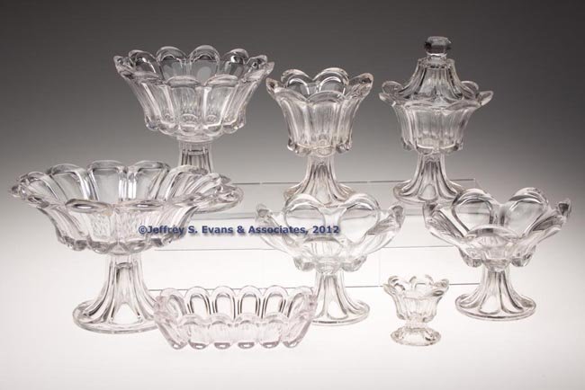 PRESSED LOOP / LEAF TABLE ARTICLES, LOT OF SEVEN: PRESSED LOOP / LEAF TABLE ARTICLES, LOT OF SEVEN, colorless lead glass, comprising three compotes on high standards and two sugar bowls, one lacking cover, all raised on an Elongated Loop foot; a rect