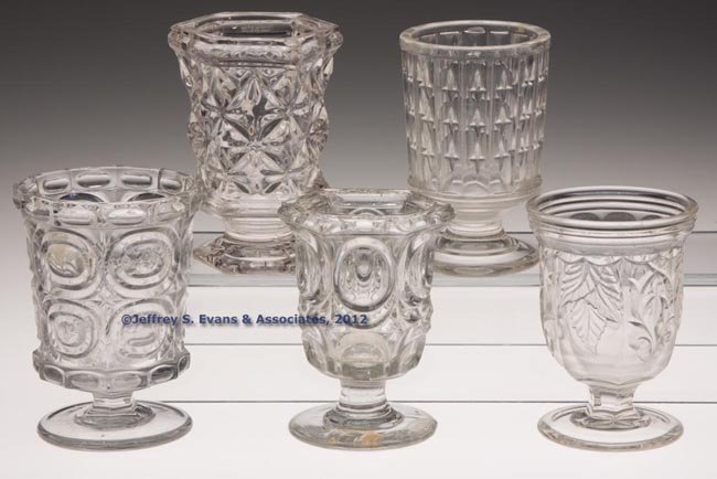 VARIOUS PRESSED EAPG SPOON HOLDERS / SPILLS, LOT O: VARIOUS PRESSED EAPG SPOON HOLDERS / SPILLS, LOT OF FIVE, colorless lead glass, including an unlisted Heavy Prism with Stars and Sandwich Star, each with a polished pontil mark. 1850-1870. 4 3/4" to 5