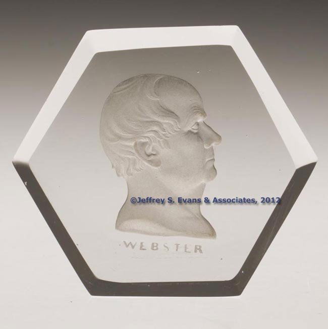 DANIEL WEBSTER PAPERWEIGHT: DANIEL WEBSTER PAPERWEIGHT, colorless, hexagonal form with a frosted intaglio bust inscribed "WEBSTER" below, polished upper edges. New England Glass Co. Circa 1850. 1 1/8" H, 3 1/2" DOA. Literature: