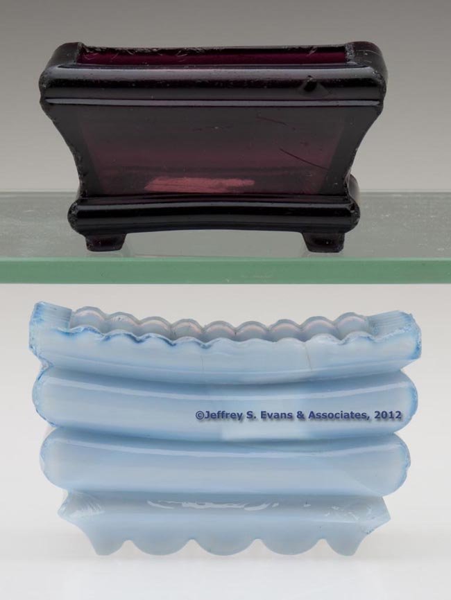 RECTANGULAR HEAVY PRESSED SALTS, LOT OF TWO: RECTANGULAR HEAVY PRESSED SALTS, LOT OF TWO, comprising a medium amethyst example with no patterning and raised on four feet, and a deep bluish opalescent example with an even-scallop rim, two heavy h