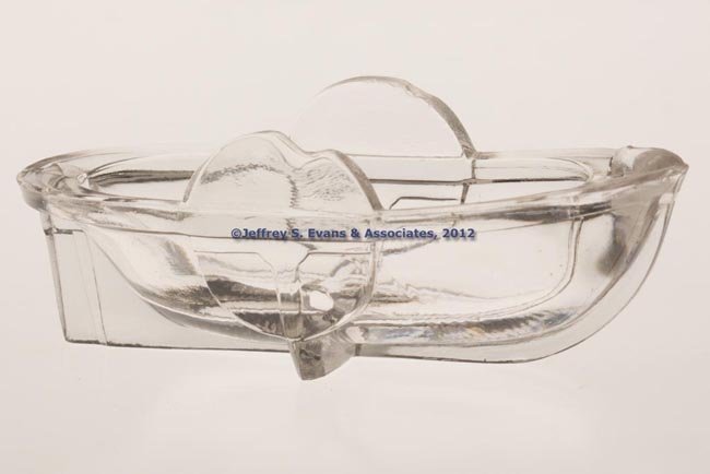 SIDE-WHEEL STEAMBOAT PRESSED SALT: SIDE-WHEEL STEAMBOAT PRESSED SALT, colorless lead glass, embossed acorn on top of bow. Probably Cape Cod Glass Works. 1850-1870. 1 3/8" H, 1 1/2" x 3 3/4". Provenance: From the collection of Abigail a