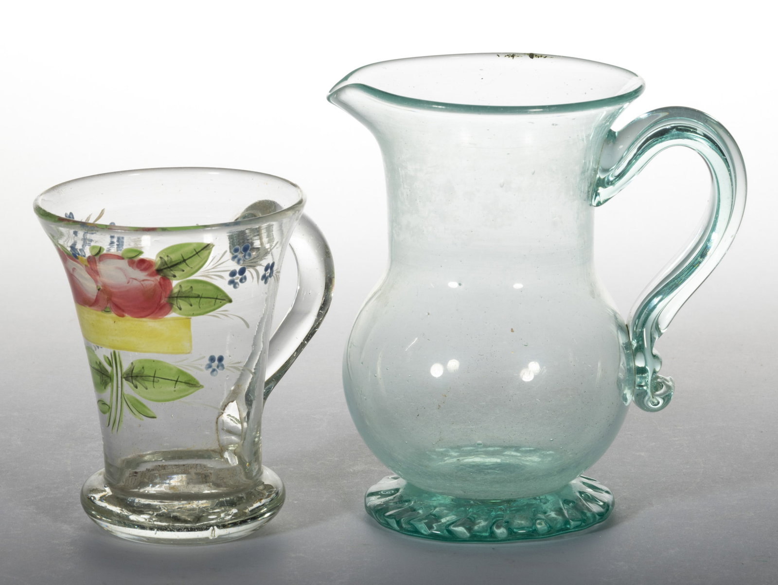 SOUTH JERSEY FREE-BLOWN PINT JUG: SOUTH JERSEY FREE-BLOWN PINT JUG, aquamarine, bulbous body with cylindrical neck and flared rim, applied medial-ridge handle, raised on a crimped foot with tubular rough pontil mark. Together with a C