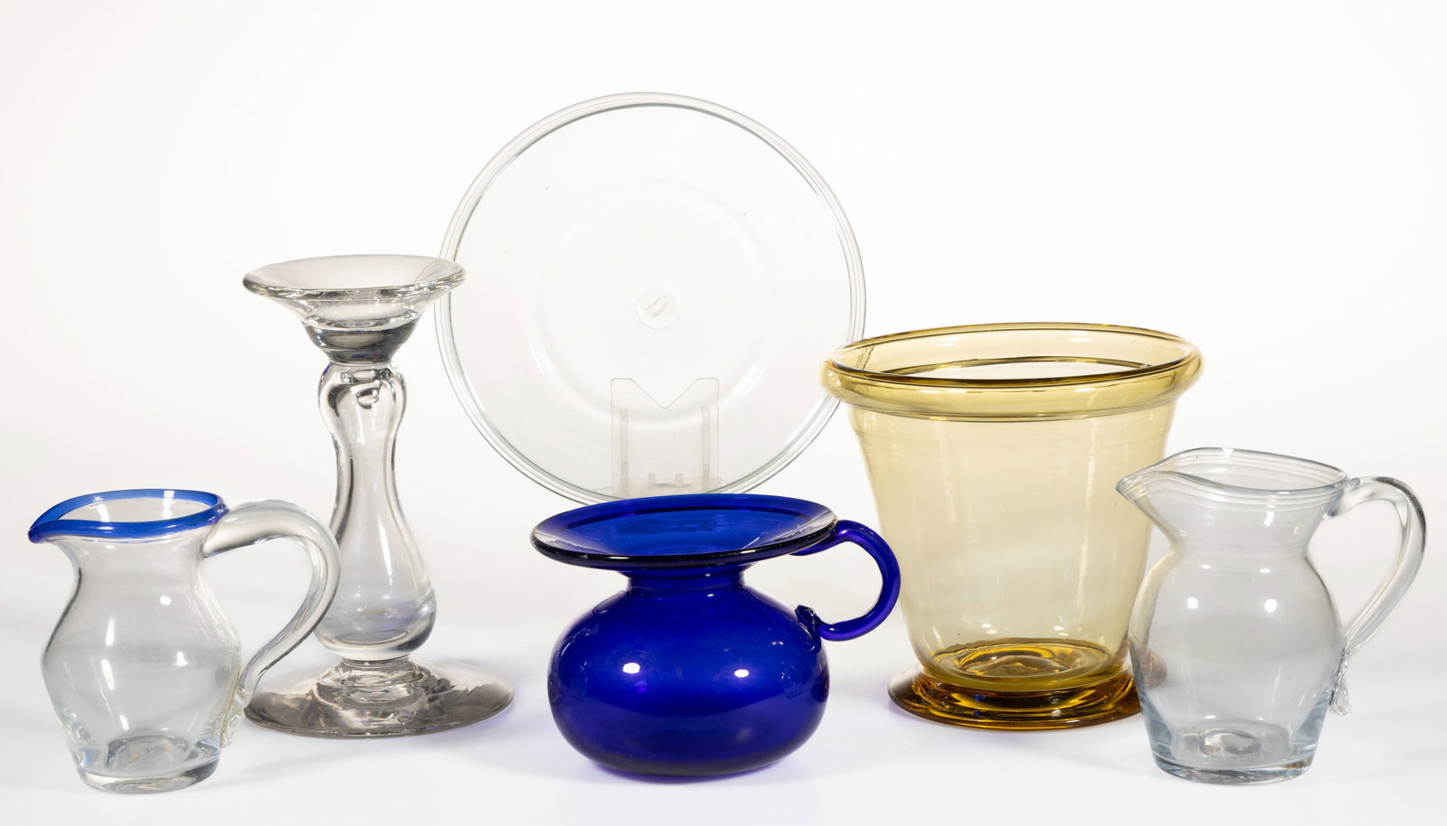 BLOWN GLASS ARTICLES, LOT OF SIX: BLOWN GLASS ARTICLES, LOT OF SIX, various colors, including a conical vase, two diminutive pitchers, and a handled spittoon. Various makers. 20th century. 3 1/8" to 6 1/4" H. Plate: 6 1