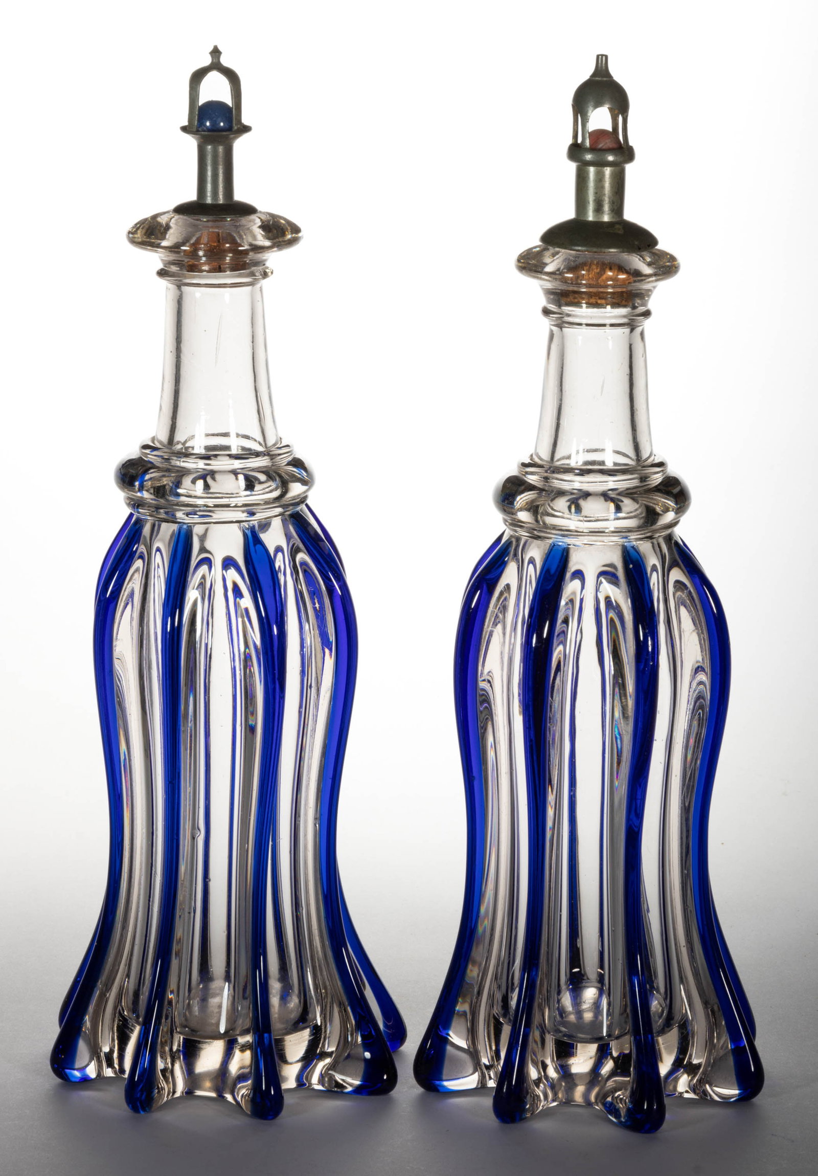 PILLAR-MOLDED PAIR OF QUART BAR DECANTERS: PILLAR-MOLDED PAIR OF QUART BAR DECANTERS, colorless lead glass with applied cobalt blue ribs, each being tall petticoat form with eight protruding ribs, an applied neck ring, and a sloping bar lip wi