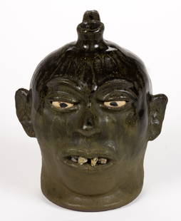 SIGNED "LANIER MEADERS" (1917-1998), WHITE CO., GEORGIA STONEWARE FACE JUG: SIGNED "LANIER MEADERS" (1917-1998), WHITE CO., GEORGIA STONEWARE FACE JUG, running to matte green alkaline-glazed, hand-modeled with inset ceramic eyes, applied ears, nose, pinched eyebrows