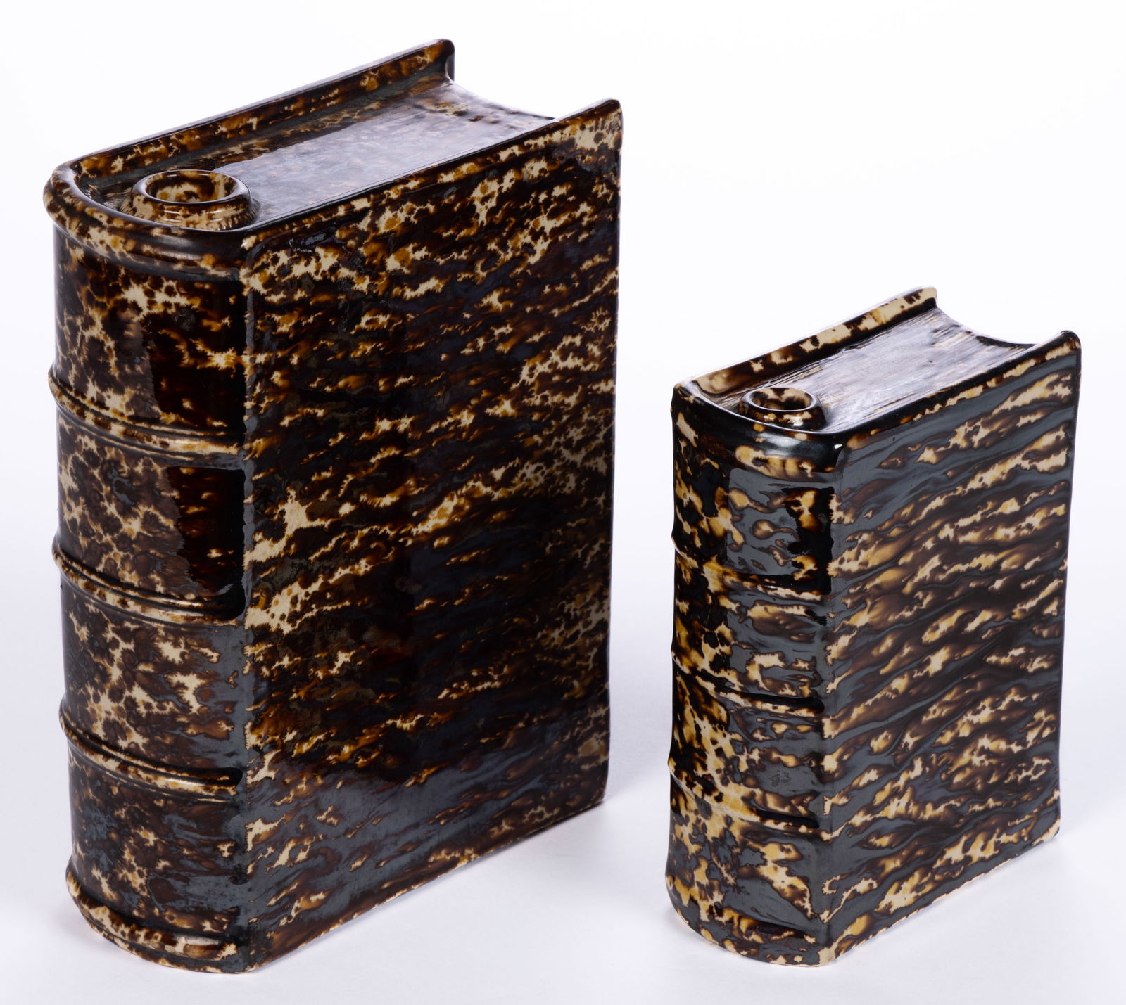 AMERICAN BENNINGTON ATTRIBUTED ROCKINGHAM-GLAZE POTTERY BOOK FLASKS, LOT OF TWO: AMERICAN BENNINGTON ATTRIBUTED ROCKINGHAM-GLAZE POTTERY BOOK FLASKS, LOT OF TWO, each mottled dark and light brown, untitled, comprising an approximately one-pint capacity example and an app