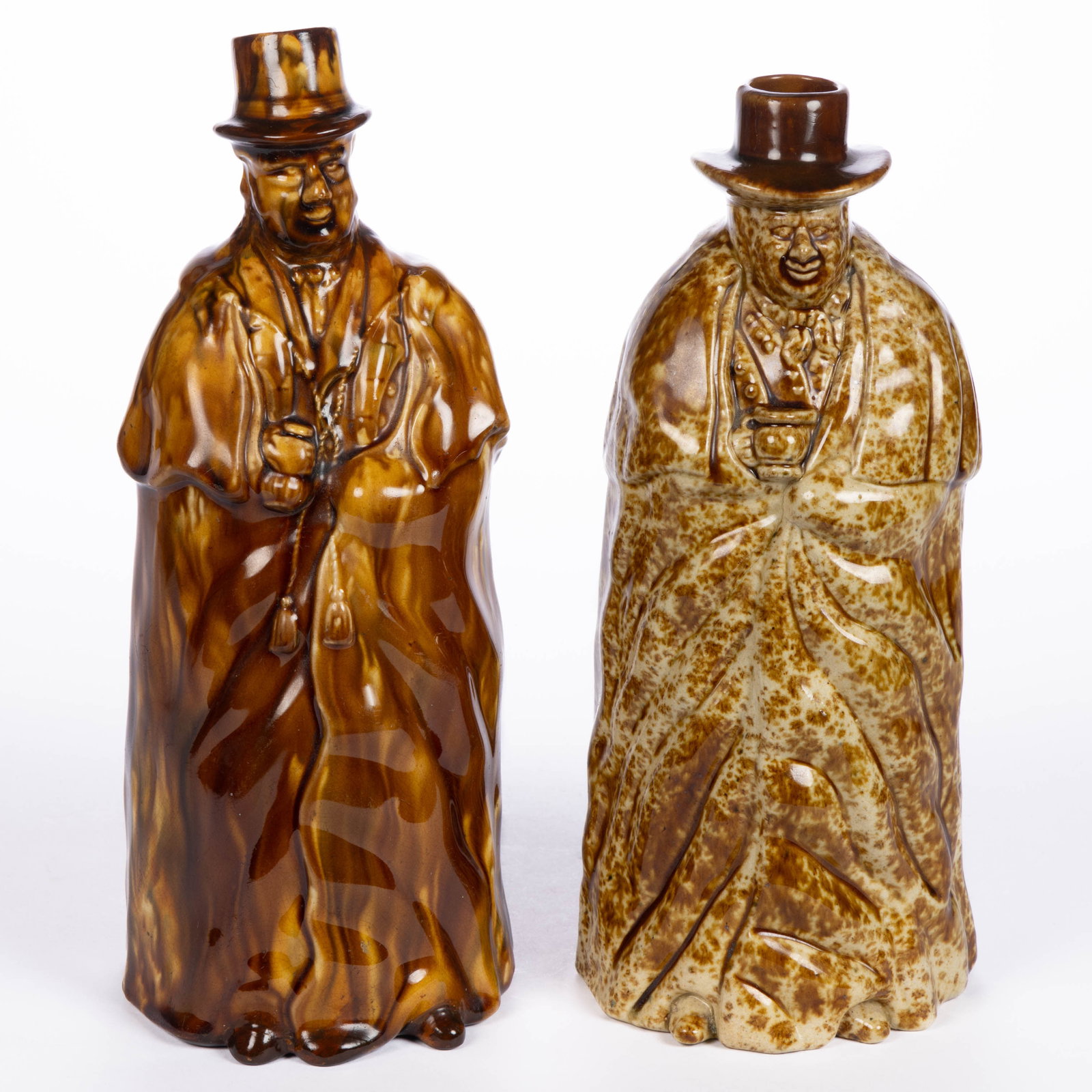 AMERICAN STAMPED BENNINGTON ROCKINGHAM-GLAZE POTTERY COACHMAN BOTTLES, LOT OF TWO: AMERICAN STAMPED BENNINGTON ROCKINGHAM-GLAZE POTTERY COACHMAN BOTTLES, LOT OF TWO, mottled brown, each depicting a standing gentleman wearing a long coat and hat, comprising one example without coat t