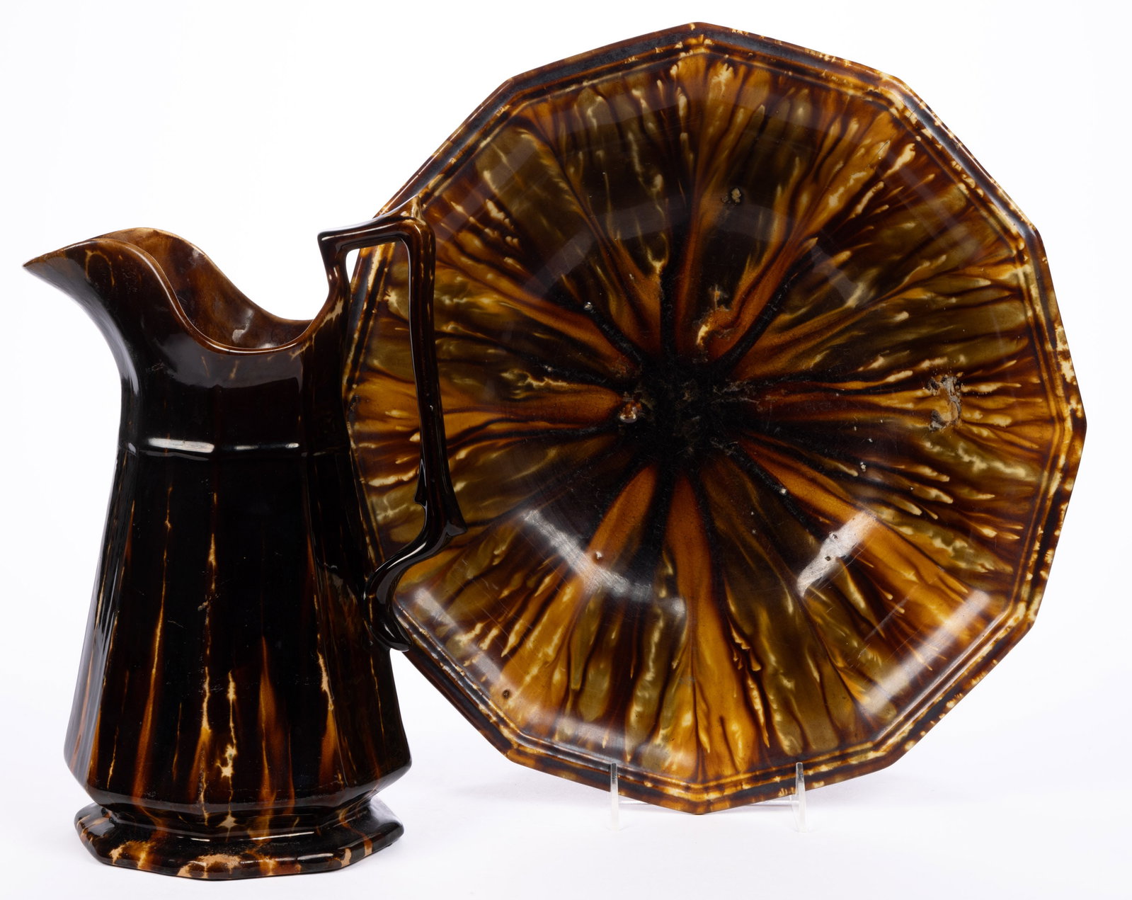AMERICAN STAMPED BENNINGTON FLINT ENAMEL ROCKINGHAM-GLAZED POTTERY WASH PITCHER AND BASIN SET: AMERICAN STAMPED BENNINGTON FLINT ENAMEL ROCKINGHAM-GLAZED POTTERY WASH PITCHER AND BASIN SET, mottled brown and orange glazes, scalloped rim pattern, comprising a basin with additional olive gre