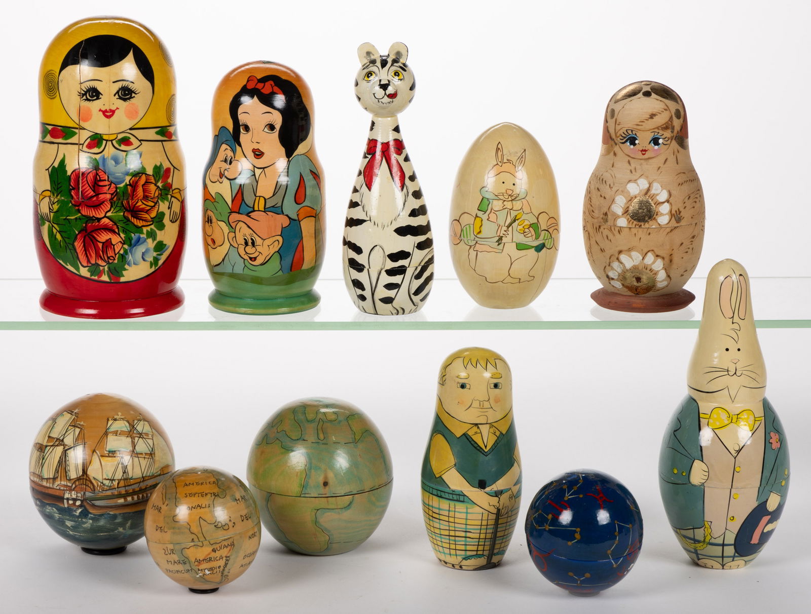 ASSORTED WOODEN NESTING DOLLS AND RELATED, LOT OF 11: ASSORTED WOODEN NESTING DOLLS AND RELATED, LOT OF 11, including Snow White and the Seven Dwarfs, Rabbits, and globes. 20th/21st century. 8" HOA, Provenance: From the collection of Betty Dr