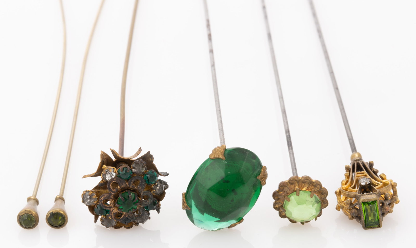 ANTIQUE / VINTAGE GREEN GLASS STONE / RHINESTONE HATPINS, LOT OF SIX: ANTIQUE / VINTAGE GREEN GLASS STONE / RHINESTONE HATPINS, LOT OF SIX, comprising an Art Deco example with openwork top having a green glass baguette to tip and two colorless rhinestones to sides, one 