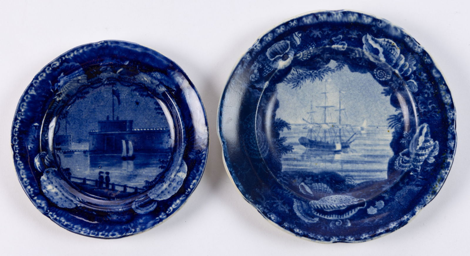 STAFFORDSHIRE AMERICAN VIEW / NAUTICAL MOTIF TRANSFER-PRINTED CERAMIC CUP PLATES, LOT OF TWO: STAFFORDSHIRE AMERICAN VIEW / NAUTICAL MOTIF TRANSFER-PRINTED CERAMIC CUP PLATES, LOT OF TWO, comprising one featuring Frigate at Anchor, depicting a tall-masted ship with sails down, and one fea
