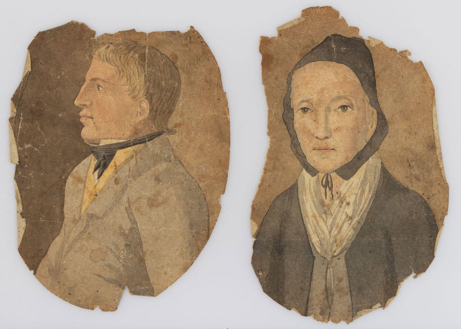 PAIR OF CONTINENTAL SCHOOL (19TH CENTURY) FOLK ART PORTRAITS: PAIR OF CONTINENTAL SCHOOL (19TH CENTURY) FOLK ART PORTRAITS, watercolor on paper, having bust-length depictions, comprising one with profile of a man, and the other of an elderly woman wear