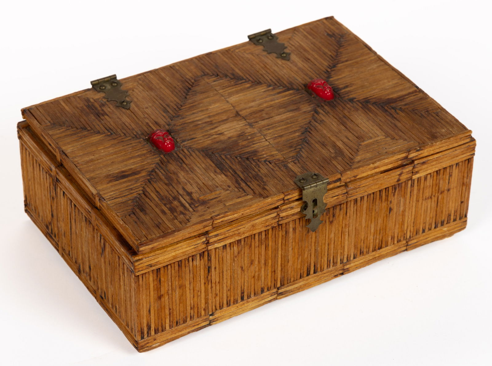 AMERICAN TRAMP ART MATCHSTICK BOX: AMERICAN TRAMP ART MATCHSTICK BOX. rectangular form with hinged lid, the exterior and interior covered with wooden matchsticks, two Bakelite/plastic masks set into top of lid. Circa 1930. 3"