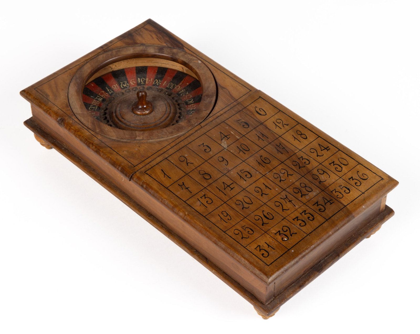 FOLK ART PAINTED MINIATURE ROULETTE WHEEL / GAMEBOARD: FOLK ART PAINTED MINIATURE ROULETTE WHEEL / GAMEBOARD, featuring hand-painted numbers, raised on applied turned ball feet, no markings located. Circa 1920. 2" H, 10" x 5". Provena