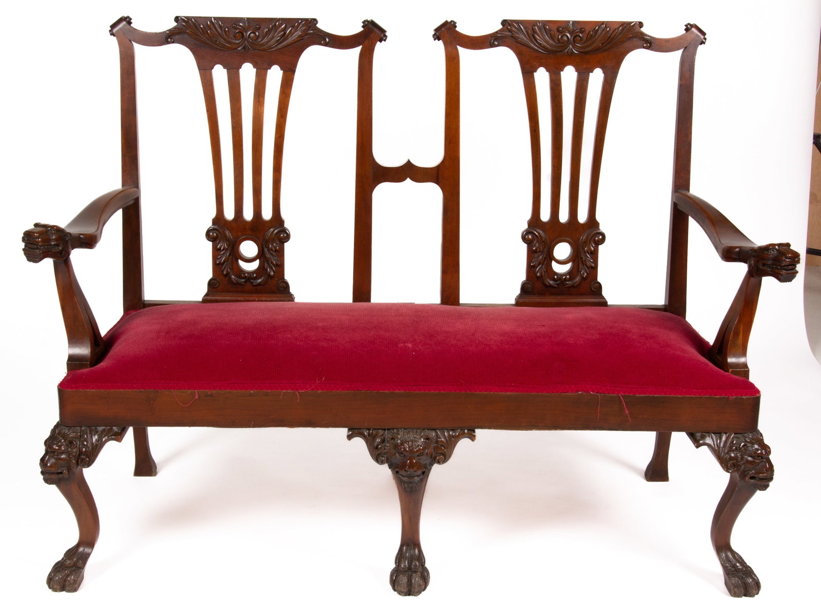 CHIPPENDALE-STYLE CARVED MAHOGANY SETTEE: CHIPPENDALE-STYLE CARVED MAHOGANY SETTEE, featuring shaped arms terminating in lions heads, raised on front feet terminating in paw feet with acanthus carved lions heads. Retains an old surface w