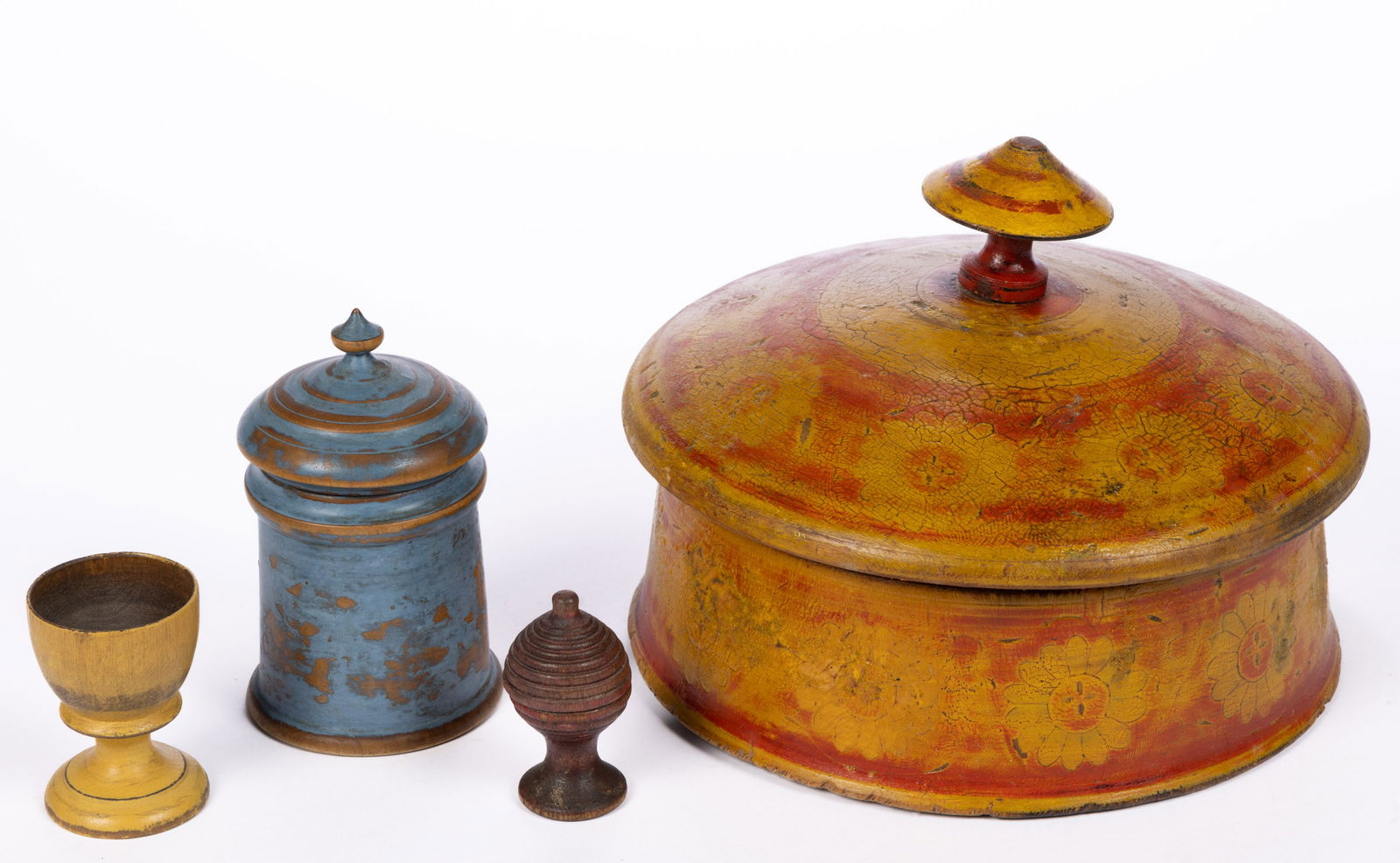COUNTRY PAINTED TURNED TREEN ARTICLES, LOT OF FOUR: COUNTRY PAINTED TURNED TREEN ARTICLES, LOT OF FOUR, comprising three covered examples, and an egg cup. Each retains an old-painted surface, blue-painted example likely later. 19th century. 2" to