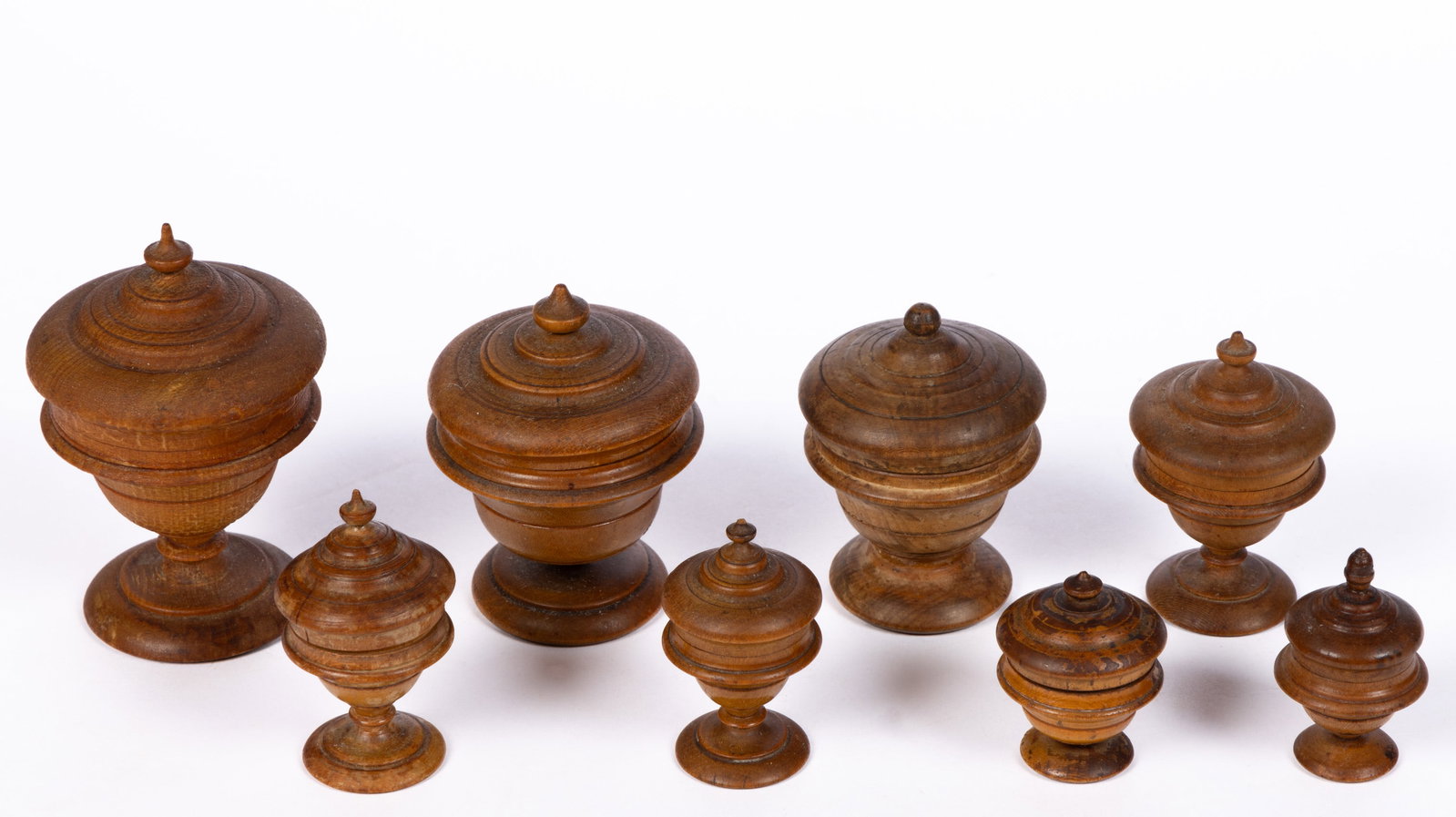AMERICAN TURNED PEASEWARE / TREEN CONTAINERS, LOT OF EIGHT: AMERICAN TURNED PEASEWARE / TREEN CONTAINERS, LOT OF EIGHT, one example retaining a Garth's auction label. Each retains an old surface with warm color. 19th century. 1 1/2" to 3 1/2" H. 