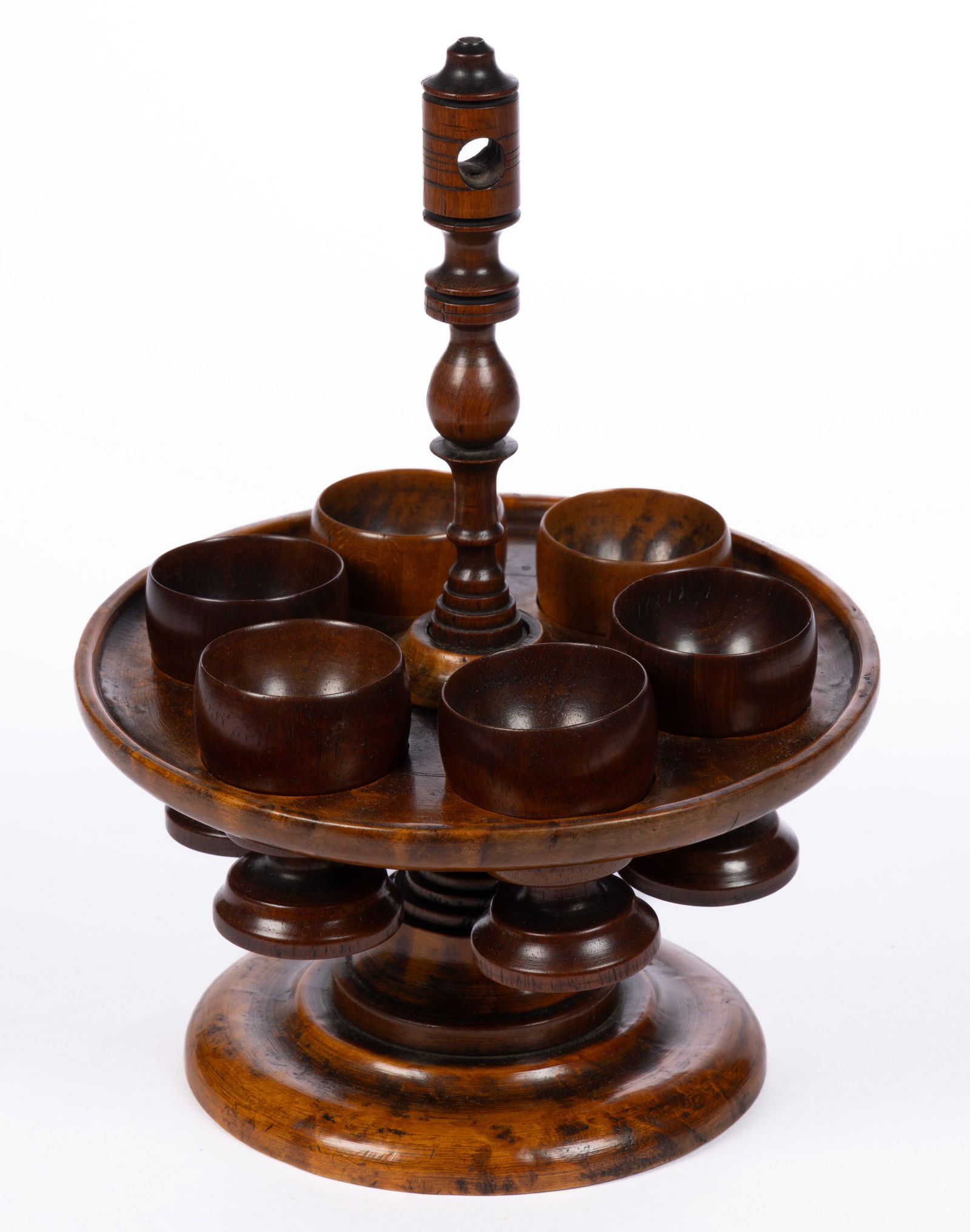 COUNTRY TREEN TURNED EGG / CUP HOLDER: COUNTRY TREEN TURNED EGG / CUP HOLDER, birdseye maple frame, with six cups. Retains an old surface with rich color. 19th century. 9" HOA. Provenance: From the William D. Annable