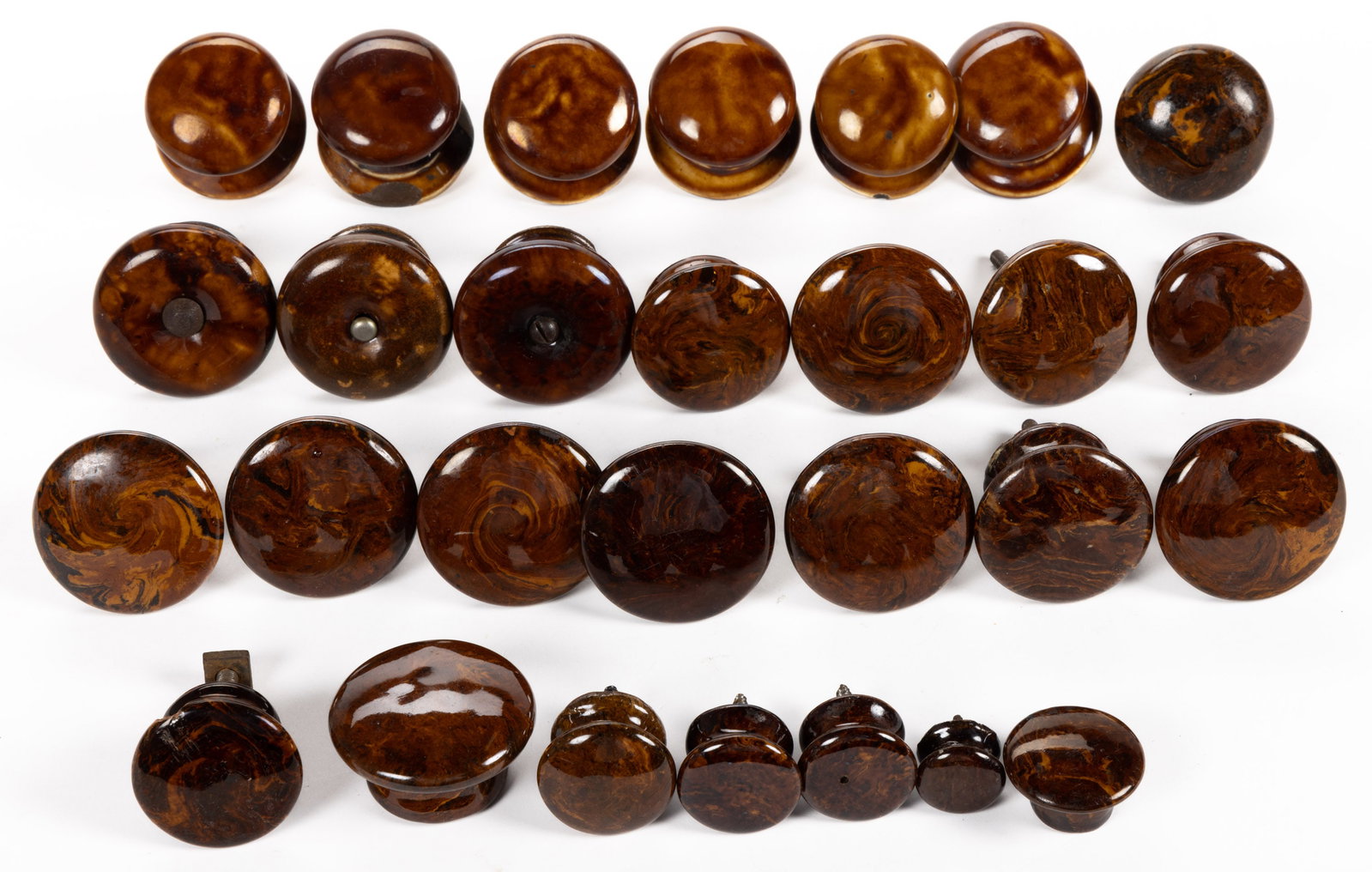 ASSORTED CERAMIC KNOBS / PULLS, LOT OF 28: ASSORTED CERAMIC KNOBS / PULLS, LOT OF 28, comprising nineteen lead-glazed agateware examples including five furniture examples and fourteen door knobs, and nine Rockingham-glazed door 