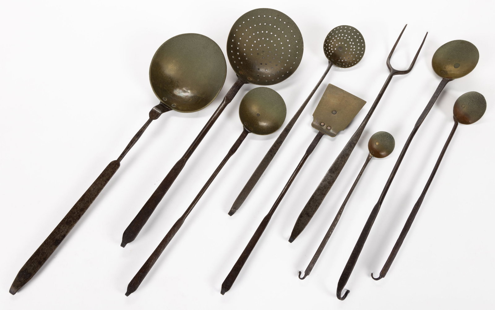 ASSORTED WROUGHT-IRON HEARTH UTENSILS, LOT OF NINE: ASSORTED WROUGHT-IRON HEARTH UTENSILS, LOT OF NINE, comprising two tasting ladles with copper bowls, two cooking ladles, skimmer, and spatula with brass, a butchering fork, ladle, and skimmer wit