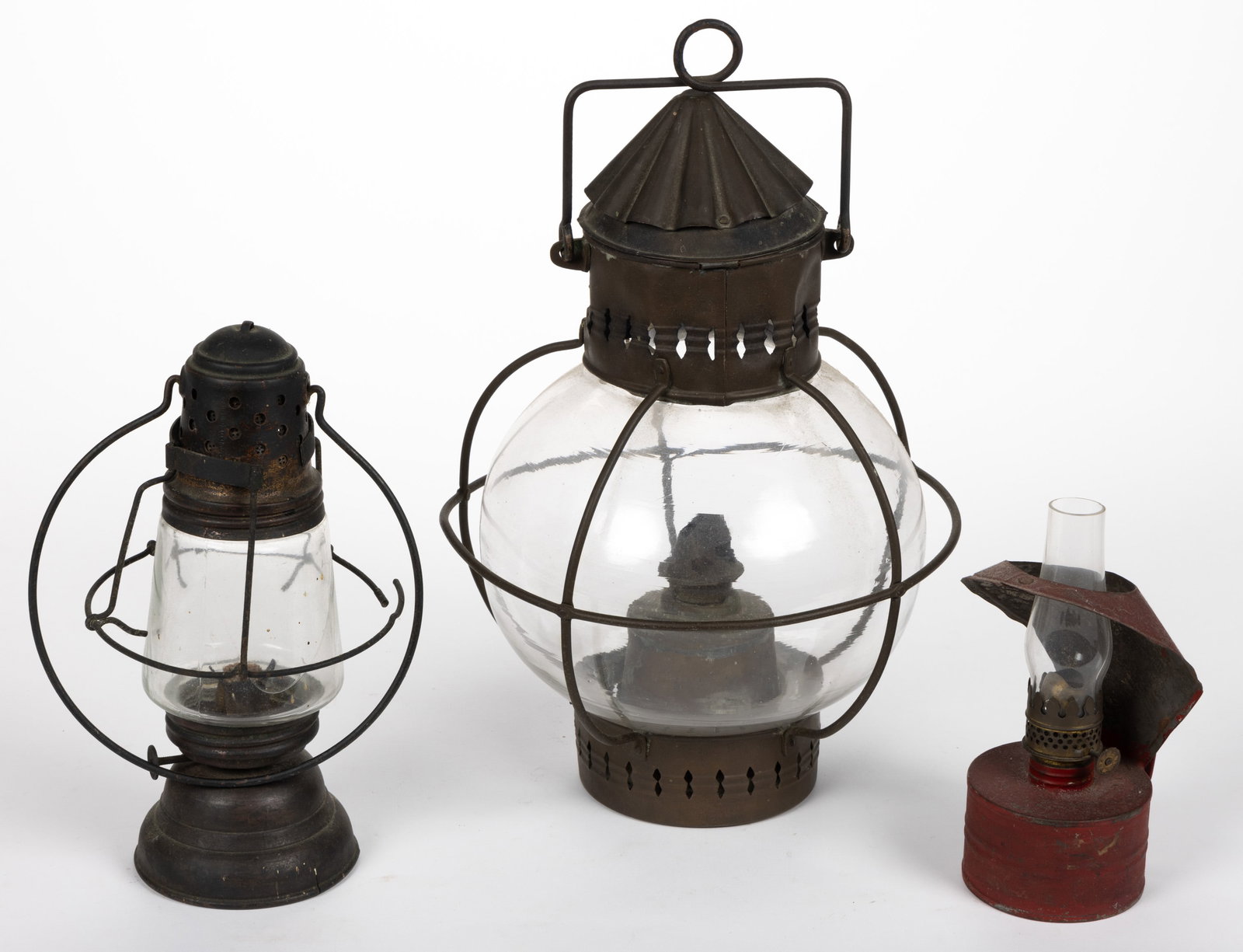ASSORTED SHEET-IRON LANTERNS, LOT OF THREE: ASSORTED SHEET-IRON LANTERNS, LOT OF THREE, comprising a brass marine lantern, ribbed cap over an open-work band, colorless fixed ball-form globe, wire guard and bail handle, fitted with a brass font 