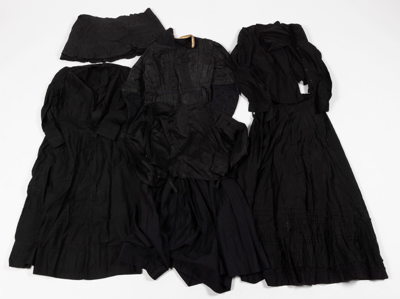 VICTORIAN / ANTIQUE BLACK / MOURNING CLOTHING, LOT OF SEVEN: VICTORIAN / ANTIQUE BLACK / MOURNING CLOTHING, LOT OF SEVEN, comprising three bodices, a dress, two skirts, and an article that appears to been trimmed from the bottom of a skirt. Fourth quarter