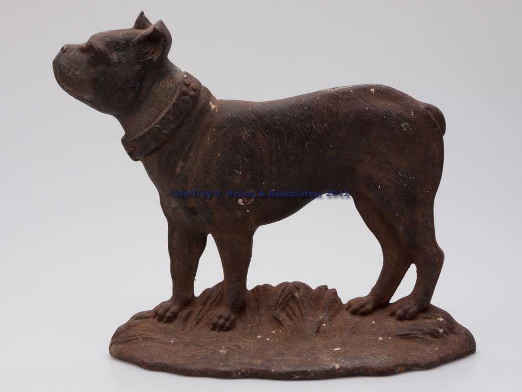 BOSTON TERRIER CAST-IRON DOORSTOP: BOSTON TERRIER CAST-IRON DOORSTOP, single sided, standing and facing left, remnants of original paint, four bumpers on reverse. Attributable to Bradley and Hubbard. First half 20th century. 9 5/8" H, 