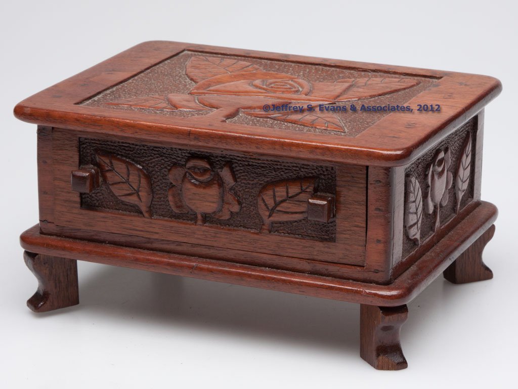 VIRGINIA CARVED WALNUT FOLK ART DRESSER BOX: VIRGINIA CARVED WALNUT FOLK ART DRESSER BOX, shallow rectangular case with single drawer and raised on four short cut-out feet, decorated with carved roses and leaves on stippled grounds full round. P