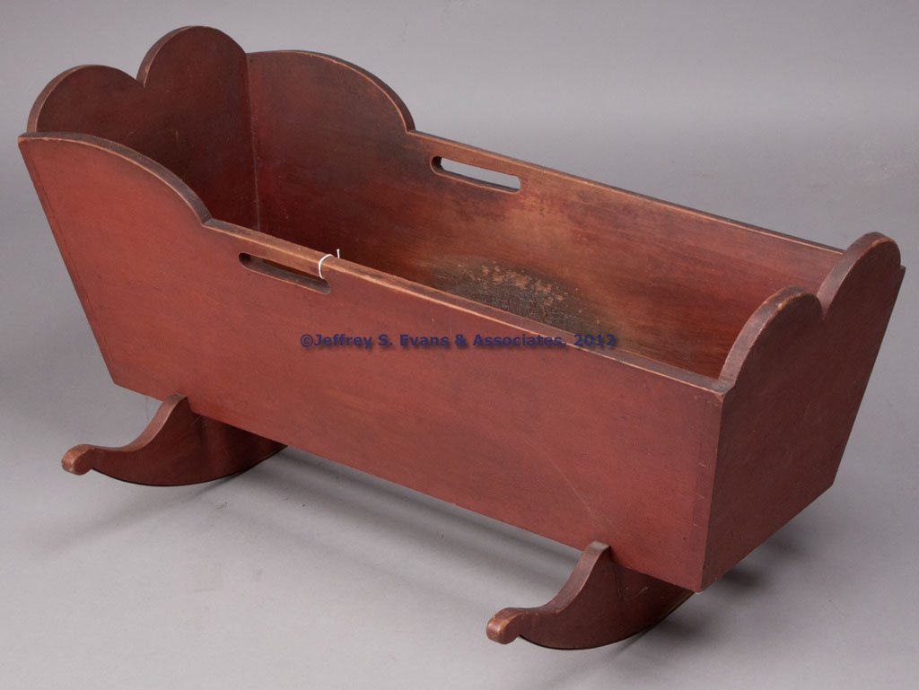 PENNSYLVANIA PAINTED POPLAR CRADLE: PENNSYLVANIA PAINTED POPLAR CRADLE, dovetailed case with double-tombstone ends and cut-out handles, raised on cheese-cutter rockers. Excellent original dry red-painted surface. Mid 19th century. 20 1/