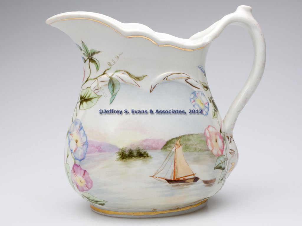 AMERICAN IRONSTONE PITCHER: AMERICAN IRONSTONE PITCHER, white with hand-painted polychrome decoration and gilt highlights, obverse with an intricate and well-executed scene featuring a large house with a family in the foreground