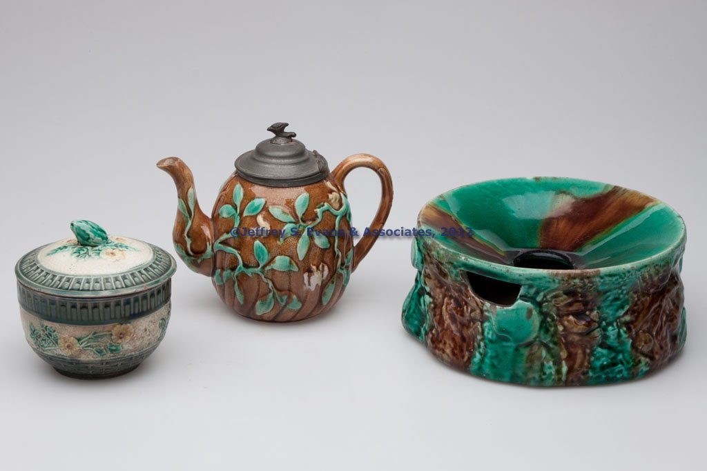 MAJOLICA ARTICLES, LOT OF THREE: MAJOLICA ARTICLES, LOT OF THREE, polychrome decoration, comprising a teapot with a hinged pewter cover, an unmarked Etruscan Wild Rose covered sugar bowl, impressed "M13" on base, and a spittoon. Late